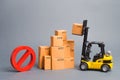 Yellow Forklift truck truckraises a box over a stack of boxes and a red symbol NO. Embargo trade wars. Restriction on importation Royalty Free Stock Photo