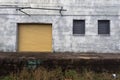 Yellow freight door on side of vintage abandoned warehouse in the south
