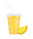 Yellow fresh pineapple juice glass and slices half. Fruit juice in clear plastic transparent cup flat lid, ice and straw tube. Royalty Free Stock Photo