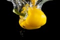 Yellow fresh bell pepper under water with reflection. Healthy colorful capsicum vegetable splashing into clear water while cooking Royalty Free Stock Photo