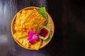 Yellow fried dumplings and a cup of sauce on a bamboo dish at decorated with orchid placed on the table dark wood. Royalty Free Stock Photo