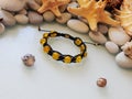Yellow friendship bracelet and pebble