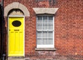 Yellow front door of an old traditional English terraced house.