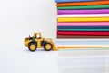 Yellow front loader truck with color cotton fabric stack on white background, textile and fashion industry Royalty Free Stock Photo