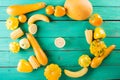 Yellow fruits and vegetables on a turquoise wooden background. Colorful festive still life. Royalty Free Stock Photo