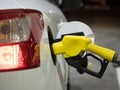 Yellow fuel nozzle in gas station at night Royalty Free Stock Photo