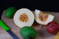 Yellow Galia melon with seeds and green raw mango