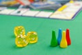 Yellow game dice for board game on a green background