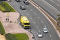 Yellow garbage truck stooped on the side of the road with traffic passing by Royalty Free Stock Photo