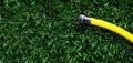 Yellow Garden Hose on Lush Green Grass Royalty Free Stock Photo