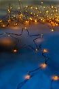 A gold star made of wire with yellow lights in the background Royalty Free Stock Photo