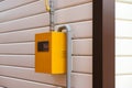 Yellow Gas Meter Box with gas pipes in it on a wall outside the house Royalty Free Stock Photo