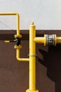 Yellow gas pipe with a crane goes along the facade of a new multi-storey building Royalty Free Stock Photo