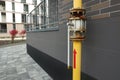 Yellow gas pipe with valve near brick wall outdoors Royalty Free Stock Photo