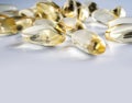 Yellow gelatin capsules with a drug Omega-3 on a grey background. Alternative treatment, beneficial body support fatty acids