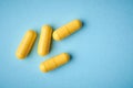 yellow gelatin capsules isolated on blue Royalty Free Stock Photo