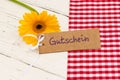 Yellow flower with gift tag german word, Gutschein, means voucher or coupon