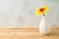 Yellow gerbera flower in vase on wooden table Royalty Free Stock Photo