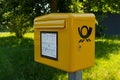 A yellow German post box installed on the street.