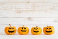 Yellow ghost pumpkins on white wooden borad background