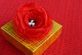 Yellow gift box with red fabric flower decoration close up Royalty Free Stock Photo