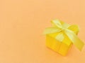 Yellow gift box on orange color background, copy space. Royalty Free Stock Photo