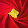 Yellow gift box with yellow ribbon on center spiral red silk background. Square.