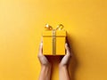 Yellow giftbox in hands Royalty Free Stock Photo