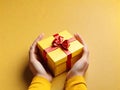 Yellow giftbox in hands Royalty Free Stock Photo