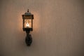 A yellow glass lantern hanging on a gray old wall. Bright glowing lantern illuminating the wall of an ancient building Royalty Free Stock Photo