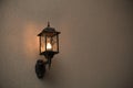 A yellow glass lantern hanging on a gray old wall. Bright glowing lantern illuminating the wall of an ancient building Royalty Free Stock Photo