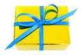 Yellow glossy gift wrapped present with blue satin bow