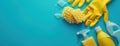 Yellow Gloves and Cleaning Supplies on Blue Background Royalty Free Stock Photo