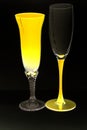 Yellow glowing wine glasses on dark background