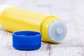 Yellow glue stick with blue lid on rustic white wood