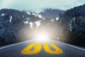 Yellow GO word written on highway road in the middle of empty asphalt road through the pine forest