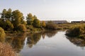 Yellow gold and green trees. Deep wide river is slowly flowing with reflections in the calm water. Forest, fields. Early morning. Royalty Free Stock Photo