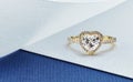 Heart Shaped Engagement Ring on Blue and White Background Royalty Free Stock Photo