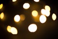 Yellow and gold lights garland in a blur on a black background. Bokeh of flying circles in the defocus. Festive atmosphere of Chri Royalty Free Stock Photo
