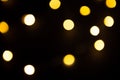 Yellow and gold lights garland in a blur on a black background. Bokeh of flying circles in the defocus. Festive atmosphere of Chri Royalty Free Stock Photo