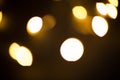 Yellow and gold lights garland in a blur on a black background. Bokeh of flying circles in the defocus. Festive atmosphere of Chri Royalty Free Stock Photo