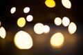 Yellow and gold lights garland in a blur on a black background. Bokeh of flying circles in the defocus. Festive atmosphere of Chri Royalty Free Stock Photo