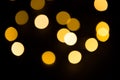 Yellow and gold lights garland in a blur on a black background. Bokeh of flying circles in the defocus. Festive atmosphere of Chri Royalty Free Stock Photo