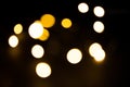 Yellow and gold lights garland in a blur on a black background. Bokeh of flying circles in the defocus. Festive atmosphere of Chri Royalty Free Stock Photo