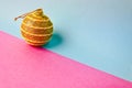 Yellow gold small round xmas festive Christmas ball, Christmas toy plastered over sparkles on a pink purple blue background Royalty Free Stock Photo