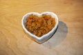 Yellow (Golden) Raisins in a heart-shaped bowl Royalty Free Stock Photo