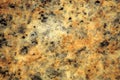 Yellow granite, polished surface of natural stone with black splashes close-up Royalty Free Stock Photo