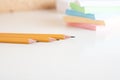Yellow graphite pensils and blured stack of note paper on background at white office desk table. Close up view Royalty Free Stock Photo