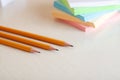 Yellow graphite pensils and blured stack of note paper on background at white office desk table. Close up view Royalty Free Stock Photo