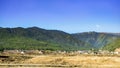 The yellow grass field with rocks and green trees mountain Royalty Free Stock Photo